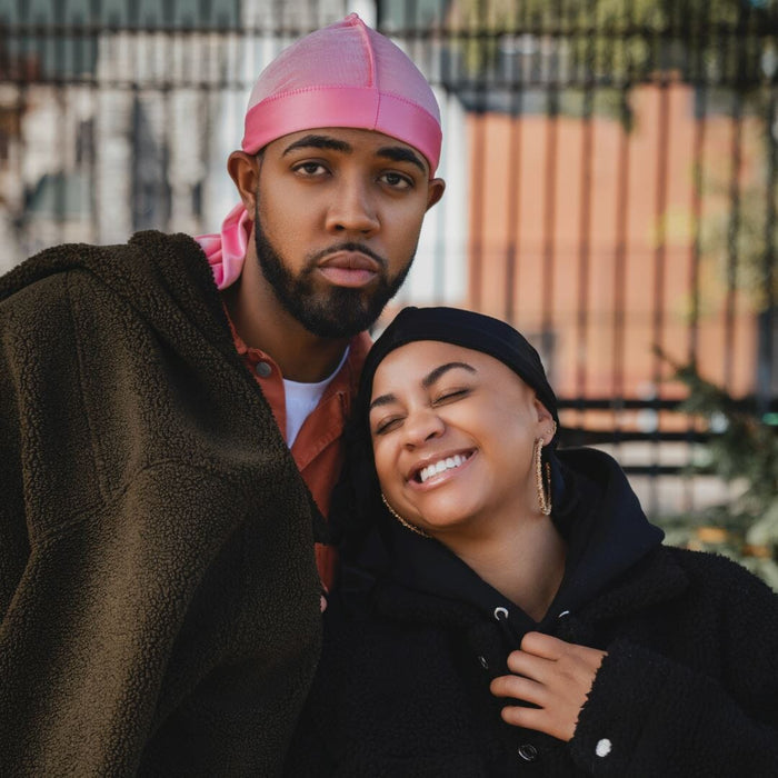 Couple wearing Dosso Beauty satin durags outdoors, showcasing hair protection and style