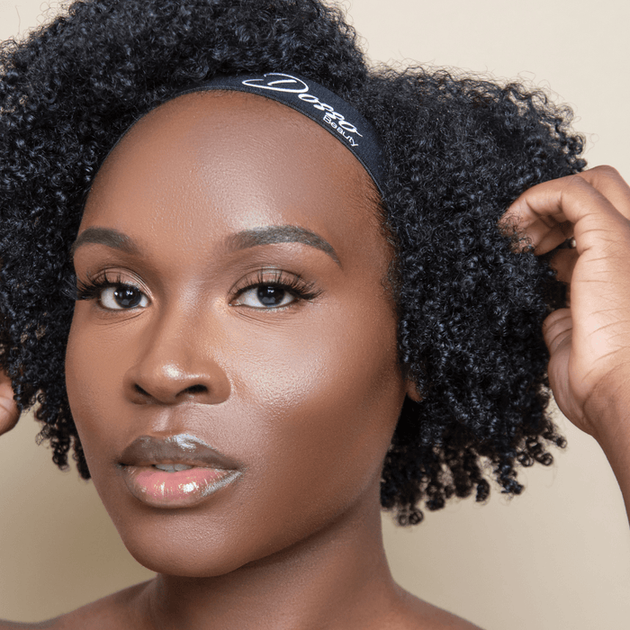 Black elastic edge band with Dosso Beauty logo is worn on a woman, holding curly hair in place and showcasing a secure, comfortable fit.