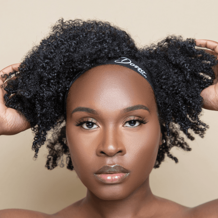 Black elastic edge band with Dosso Beauty logo is worn on a woman as she holds her curly hair, showing a secure hold and comfortable fit.