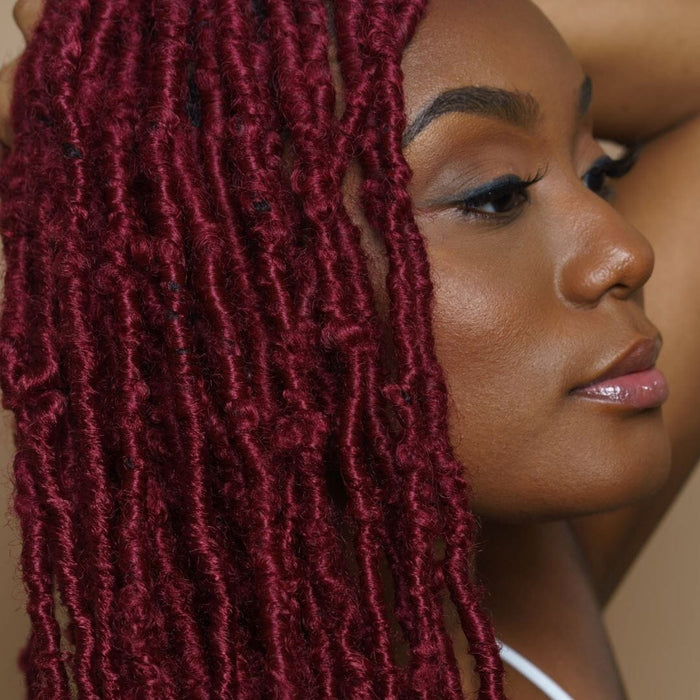 Close-up of woman with red soft locs hairstyle, showcasing texture, definition, and protective styling